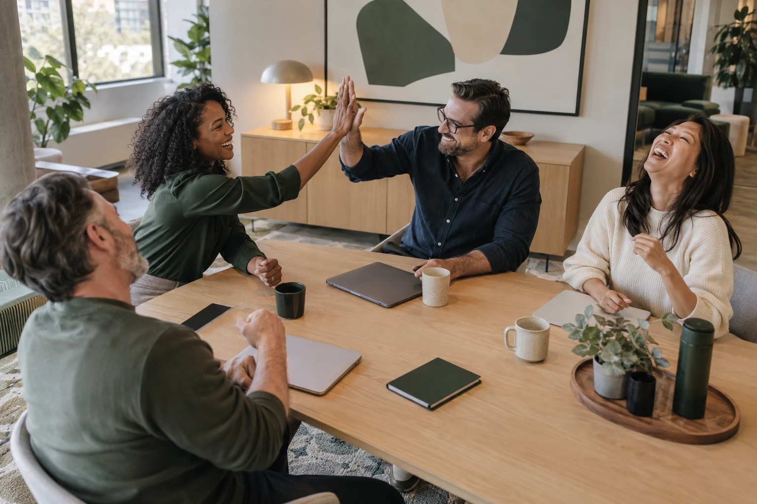 Illustrative: a sales team celebrating hitting a monthly goal around a table