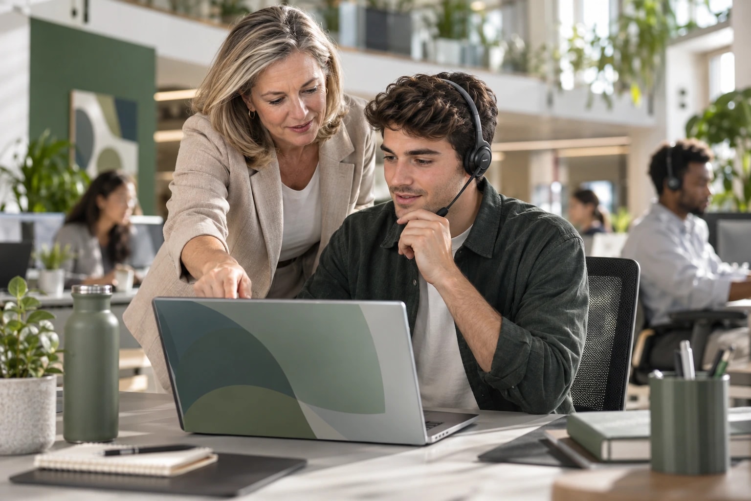 Illustrative sales team lead coaching a development rep at his desk